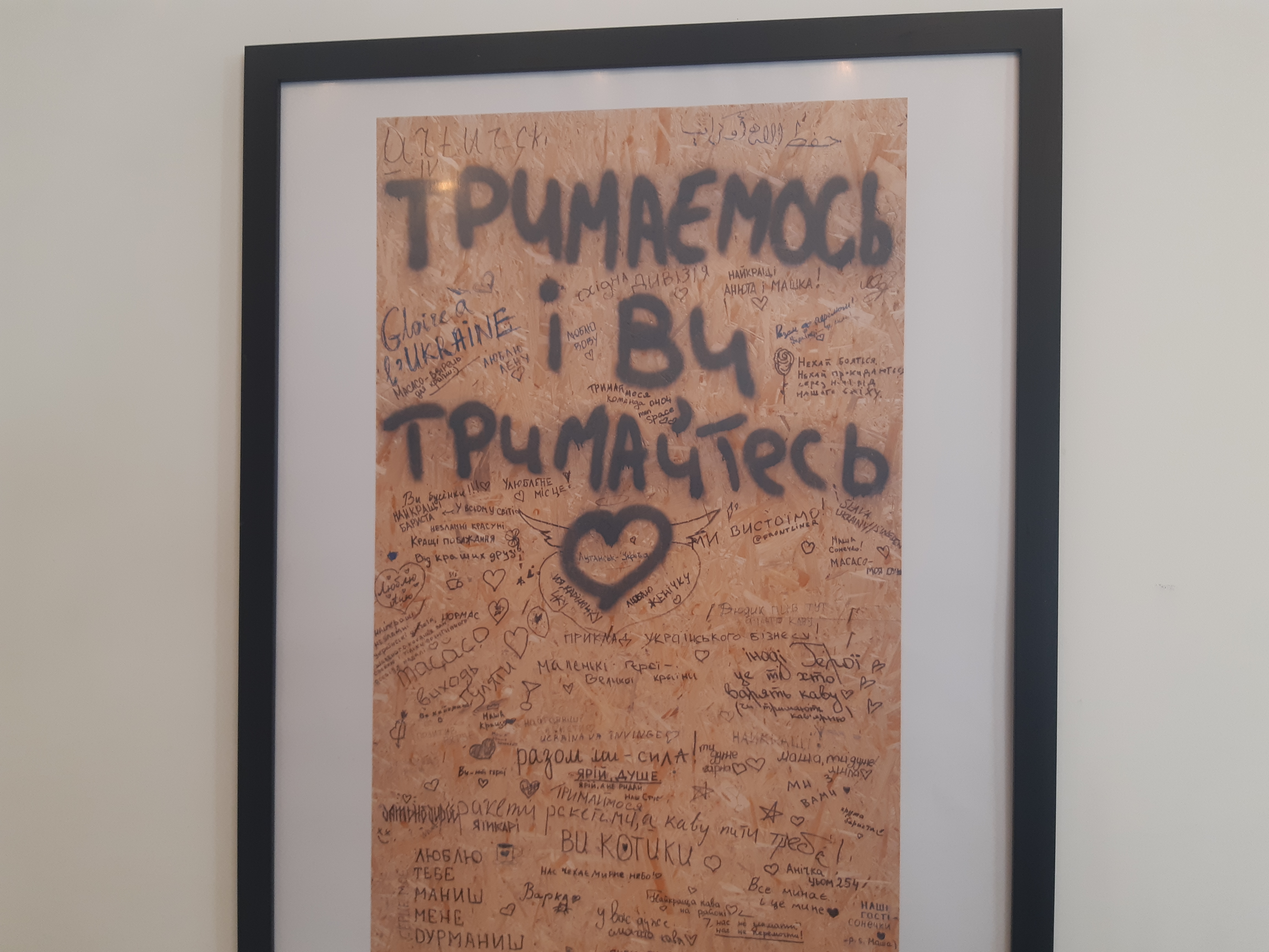 Handwritten messages from Ukrainian soldiers: „We are holding on, and you hold on too" and „Glory to Ukraine".